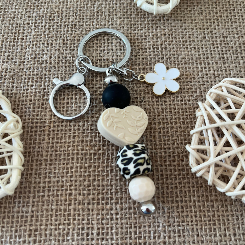 Accessoire de sac fait main en perles de silicone, porte-clés décoratif avec cœur, fleur et finitions argentées.