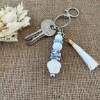 Porte-clés femme en perles de silicone avec pendentif fleur blanche et perle léopard, création artisanale.
