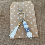 Bijou de sac en perles de silicone blanc, bleu et motif léopard, accessoire élégant pour sac à main ou trousseau de clés.