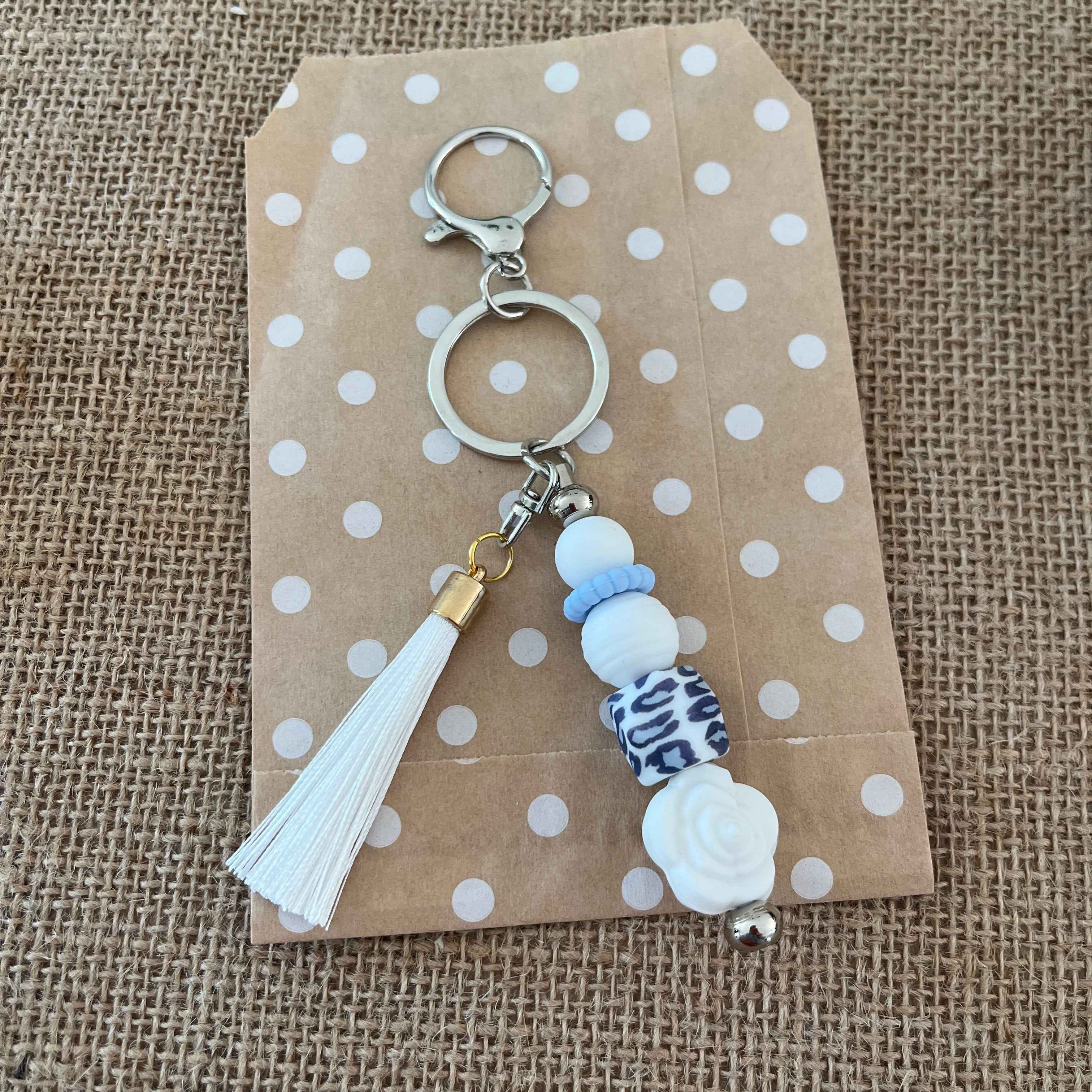 Bijou de sac en perles de silicone blanc, bleu et motif léopard, accessoire élégant pour sac à main ou trousseau de clés.