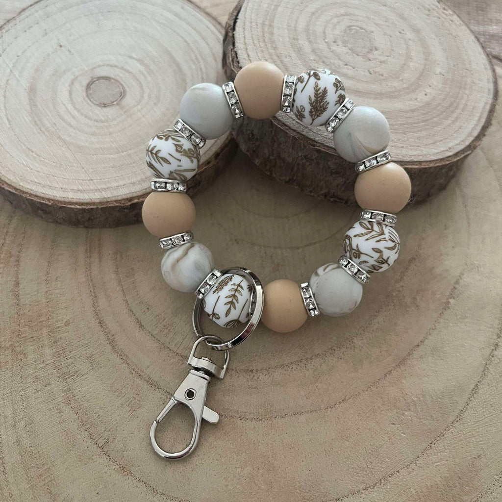 Porte-clés bracelet perlé beige & blanc – Motifs floraux dorés Ma boutique