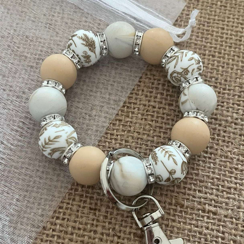 Porte-clés bracelet perlé beige & blanc – Motifs floraux dorés Ma boutique