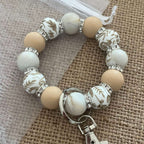 Porte-clés bracelet perlé beige & blanc – Motifs floraux dorés Ma boutique