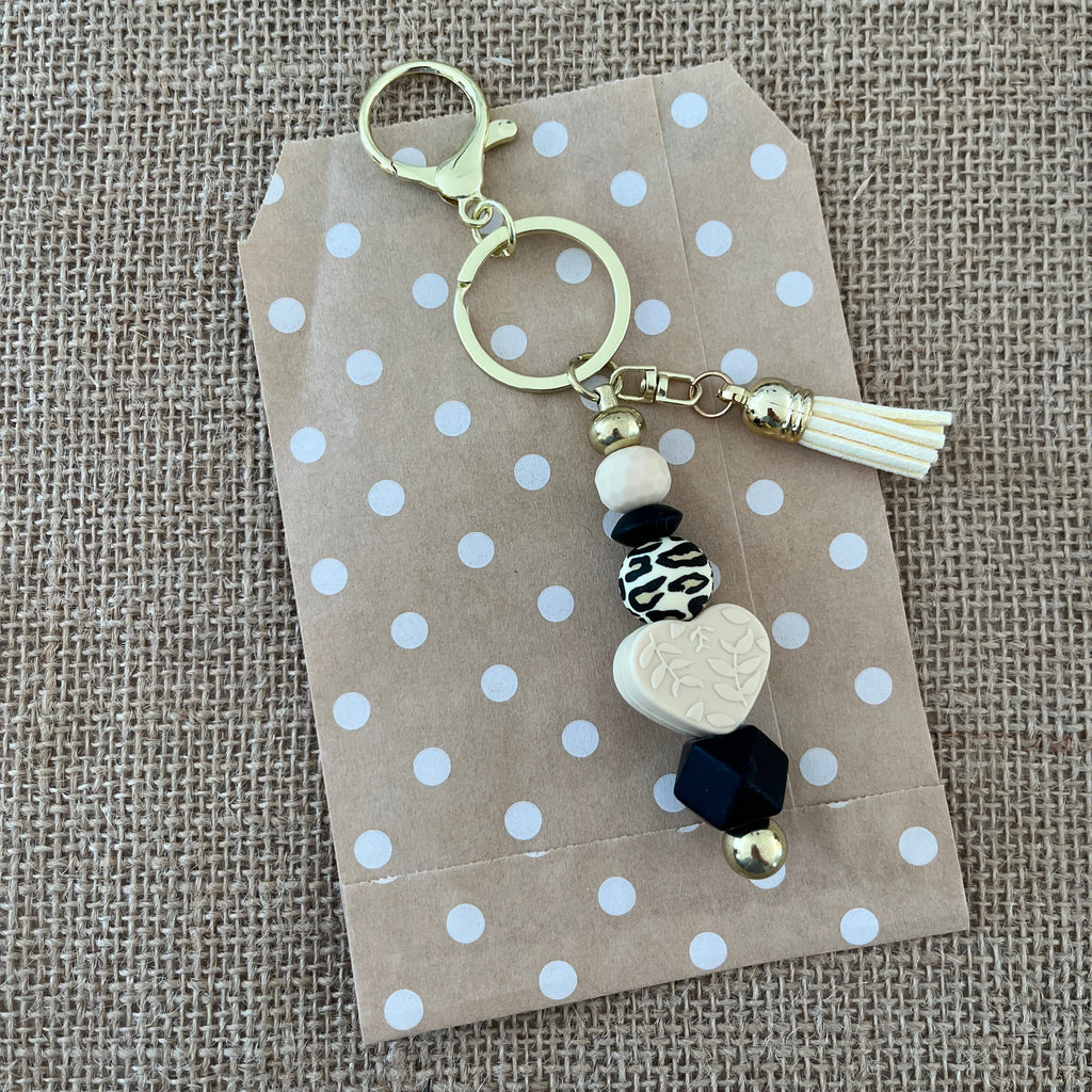 Porte-clés artisanal en silicone avec mousqueton, cœur beige, perles noires et motif léopard, idée cadeau femme originale.