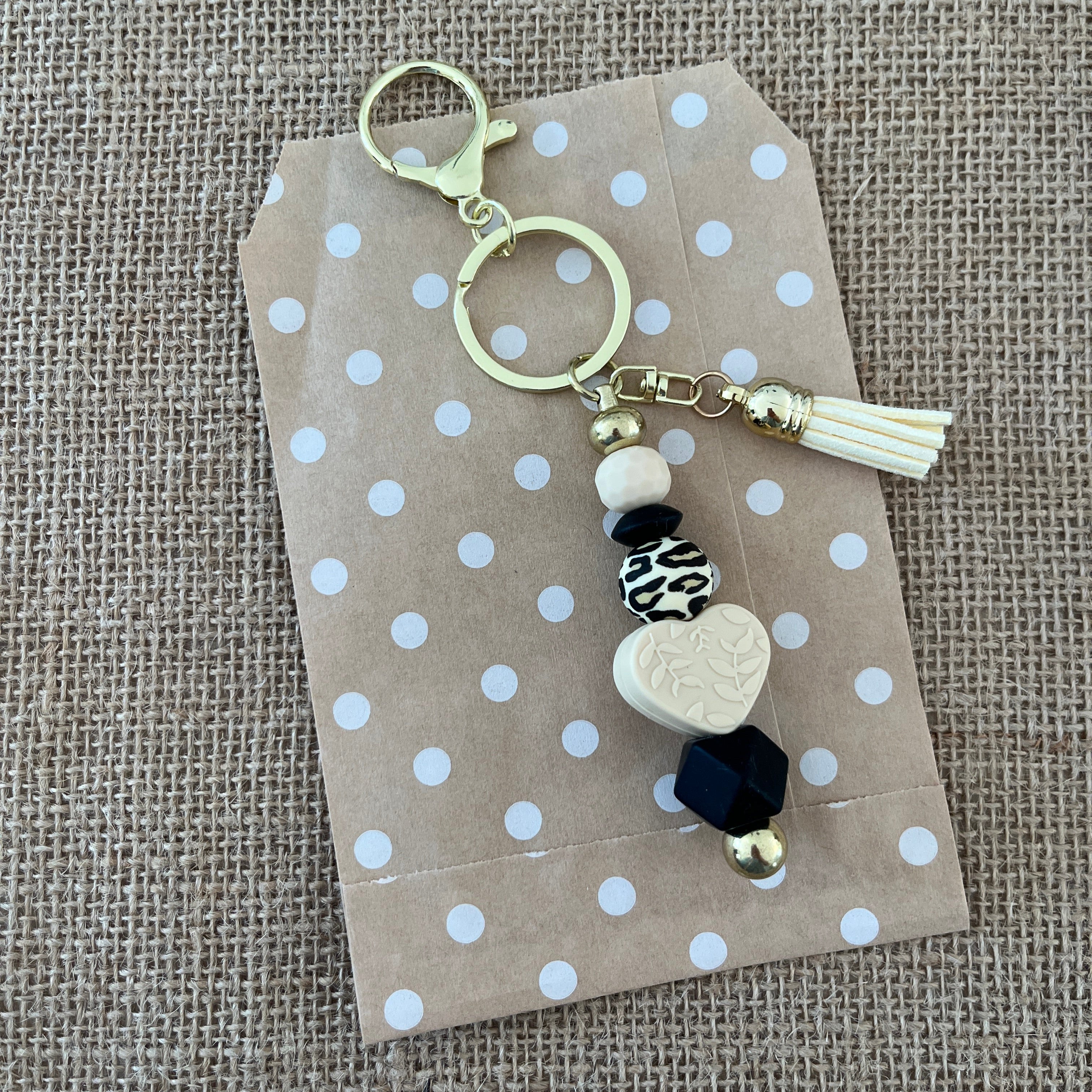 Porte-clés artisanal en silicone avec mousqueton, cœur beige, perles noires et motif léopard, idée cadeau femme originale.