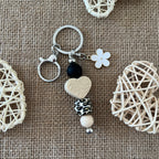 Porte-clés bijou de sac fait main en perles de silicone avec cœur beige, perle léopard, fleur blanche et mousqueton argenté.